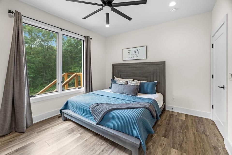 Calming bedroom with quality linens and wooded views.