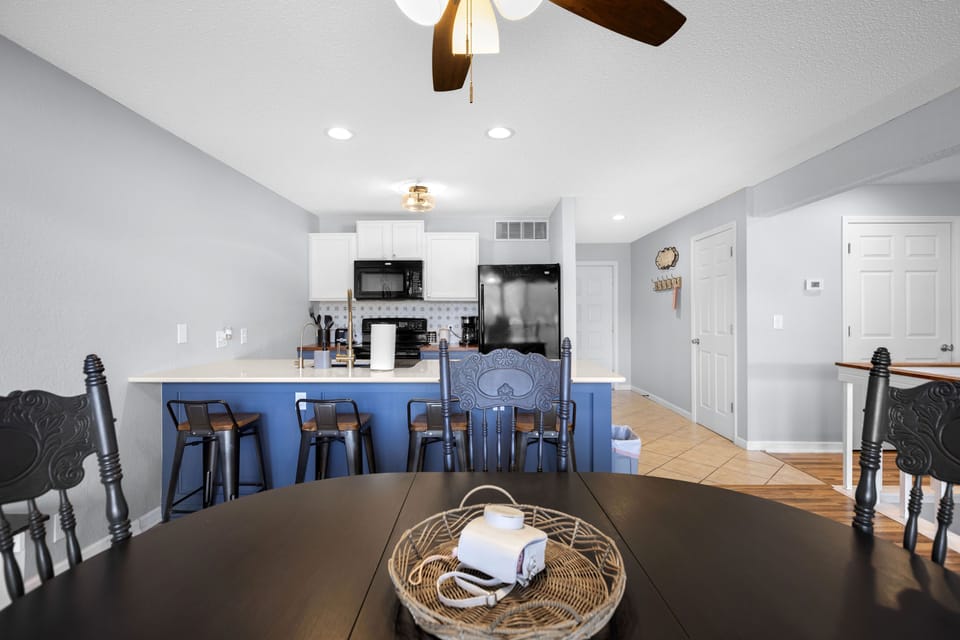 Modern kitchen with eat in bar and oven, dishwasher, microwave and refrigerator.