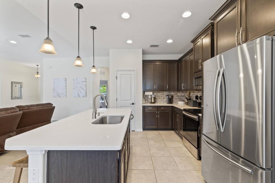 Full-size kitchen with a stove, oven, dishwasher, island, refrigerator, and all the essentials for your convenience.