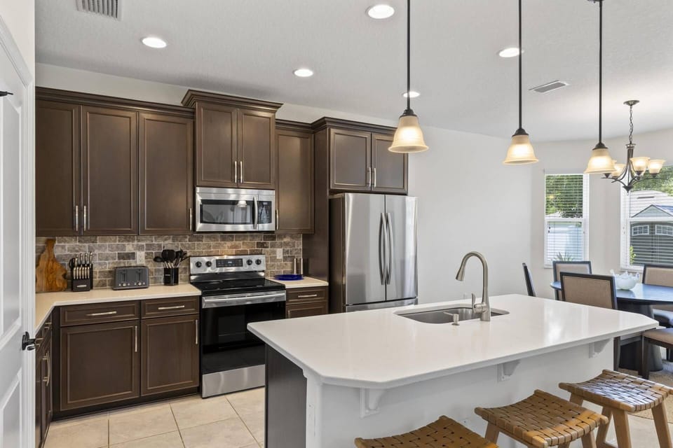 A spacious, fully-equipped kitchen with island and counter seating, perfect for preparing meals and enjoying casual bites in a stylish inviting space.
