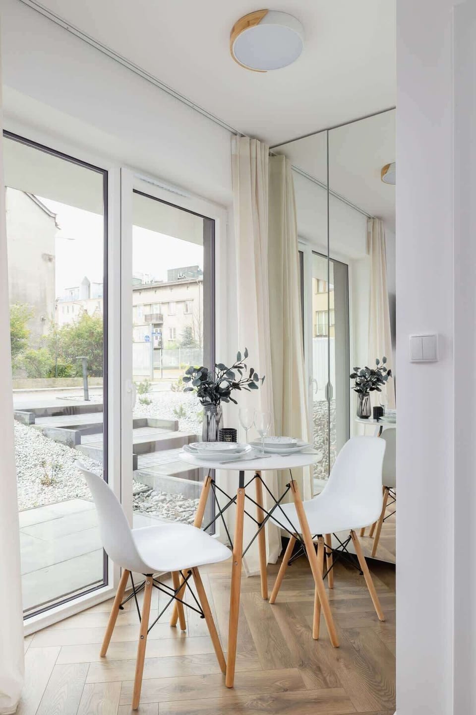A dining area with wooden furniture and large windows offering plenty of natural light.