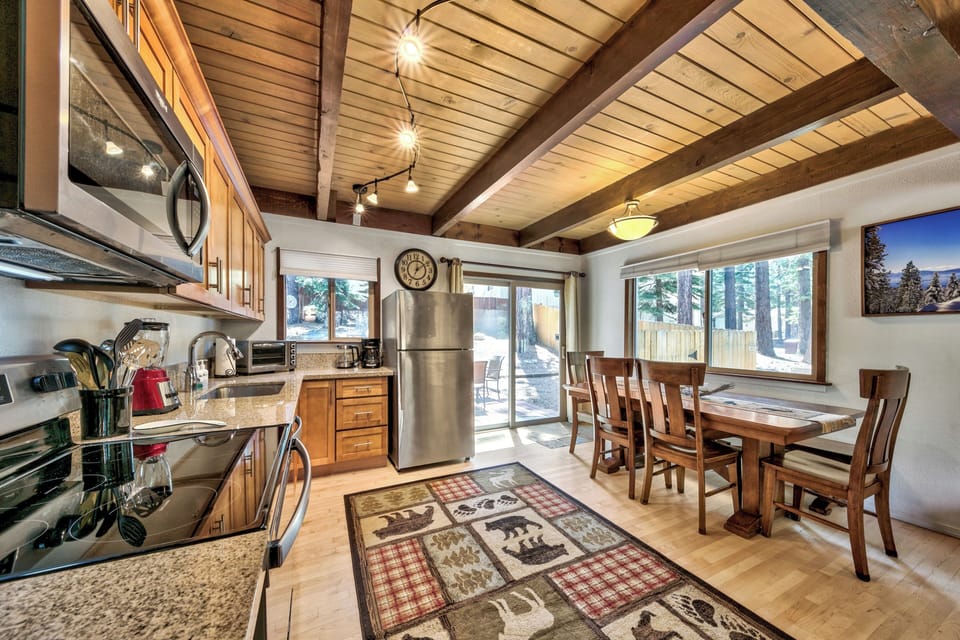 Gather around your rustic dining table where exposed beams and warm wood create the perfect mountain retreat atmosphere.