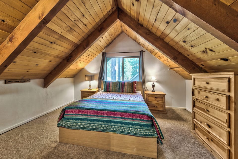Cozy up in your peaceful loft bedroom with soaring wood beams and colorful southwest-style bedding for restful mountain retreat nights.