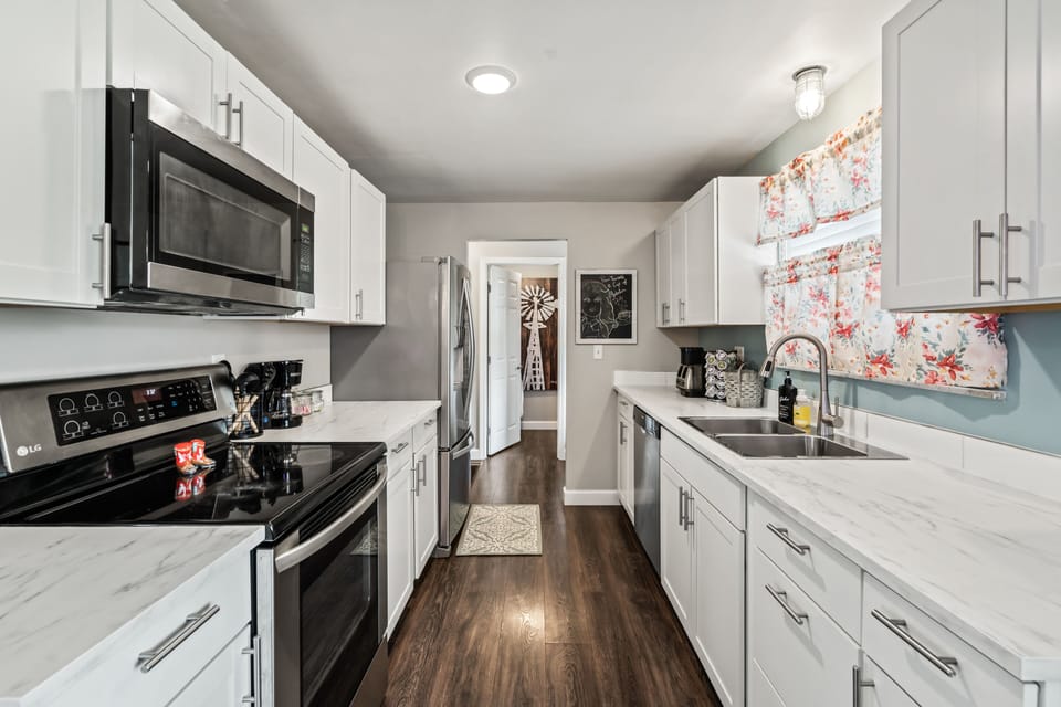 Kitchen features sleek stainless steel appliances and granite-looking counter.