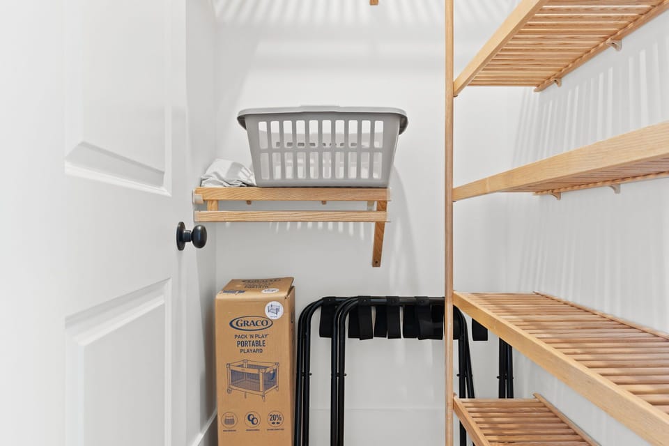 Bedroom 1 - Primary closet with Pack N Play and luggage racks