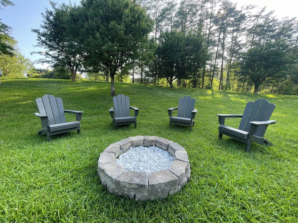 Outdoor fire pit with Adirondack chairs.