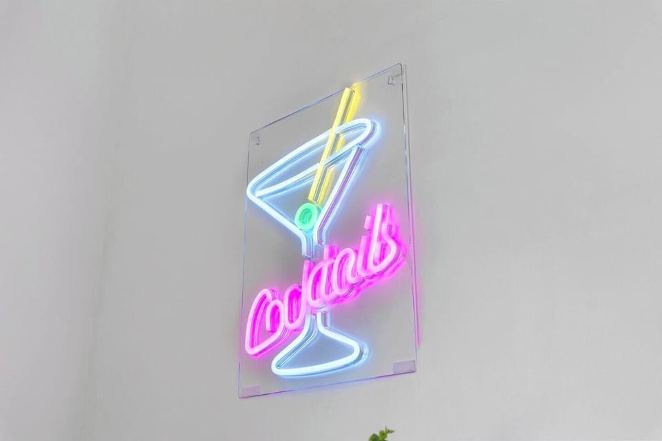 The stylish dining room boasts a vibrant neon sign that sets the tone for cocktail hour. A mini bar cart is available for mixing and serving drinks to you and your guests. The dining area provides seating for 3 at the bar counter and 6 around the dining table.
