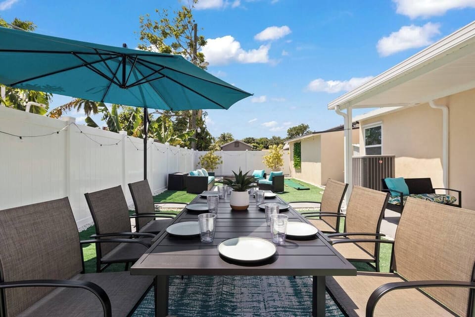 Step into this private backyard escape, complete with a dining table for 8, seating for 6, and shaded areas with extra seating. Have fun with activities like mini golf and cornhole.