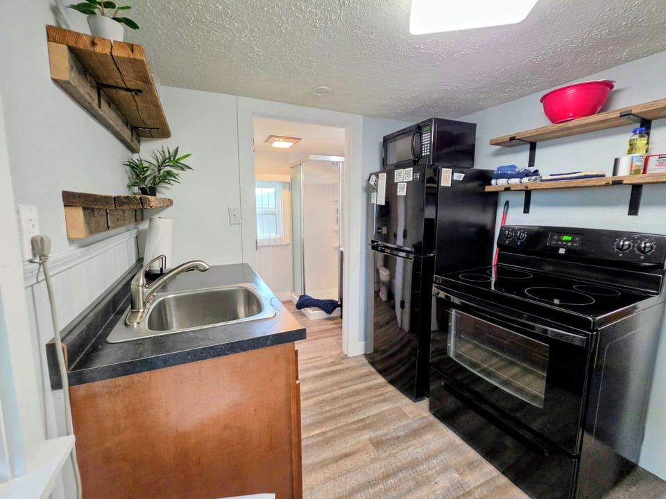 There is a microwave, stove and refrigerator.
