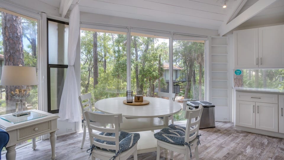 This bright dining area is surrounded by floor-to-ceiling windows that bring the natural beauty of the Sea Pines landscape indoors.