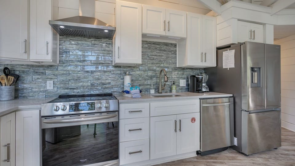 Generous counter space and thoughtful storage make meal prep effortless, while large windows bring natural light into the room.