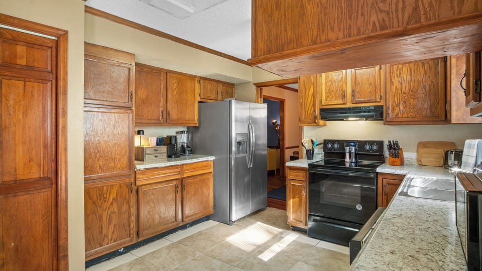 Kitchen adorned with tiled flooring and luxurious marble countertops.