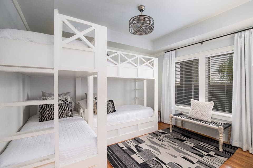 Your kids will love these stylish white bunk beds with cozy reading nooks and built-in storage baskets for their treasures.