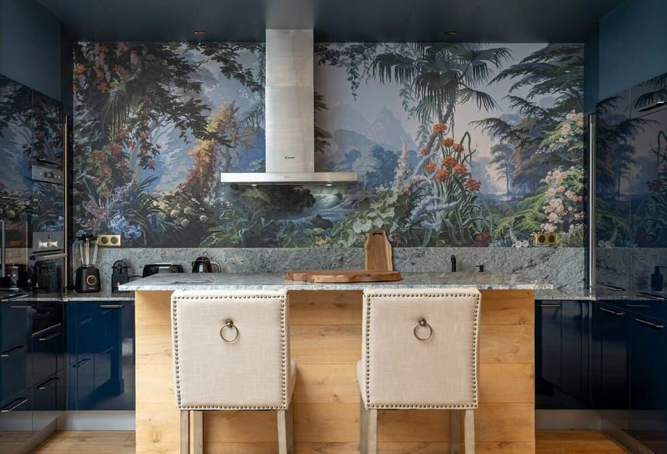 Vue sur la cuisine aménagée avec son îlot ses chaises hautes