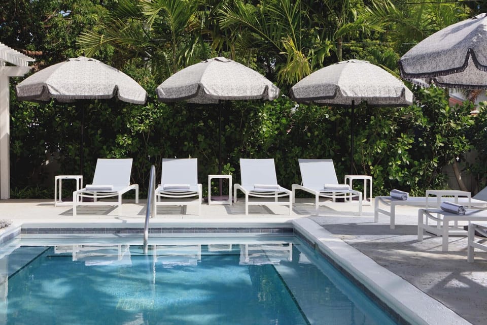 Bask poolside on cushioned loungers beneath breezy umbrellas.