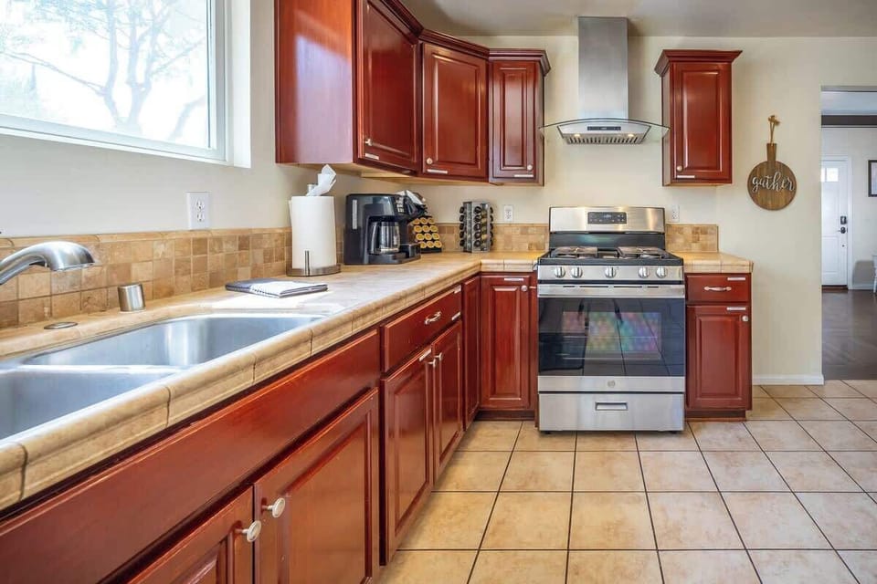 Kitchen Delight: Modern appliances and rich wood cabinetry make cooking a joy in this sunny space!