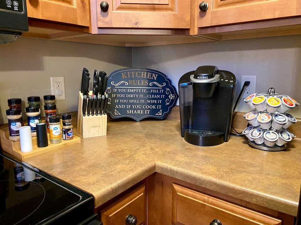 Spices and cooking utensils with Keurig coffee pot in kitchen