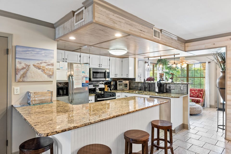 Fully stocked kitchen with 4 stools at the counter.