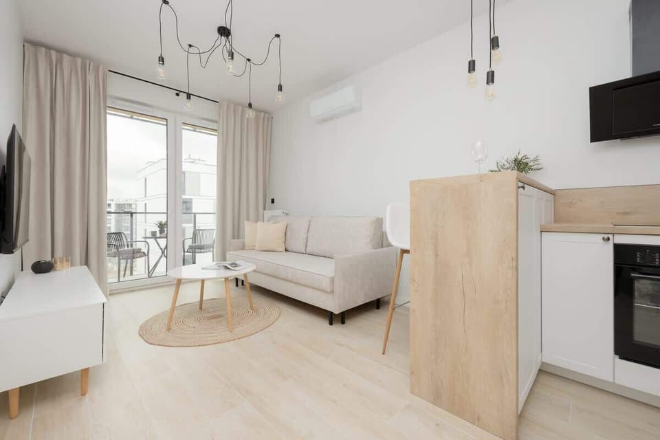 A modern interior with a stylish living room and dining area separated by vertical wooden slats. Offers both openness and a sense of zoning.