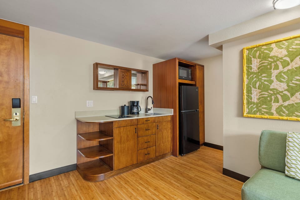 Your cozy kitchenette features warm wood cabinetry, modern appliances including a microwave and full-size refrigerator, and everything you need to prepare light meals during your stay.