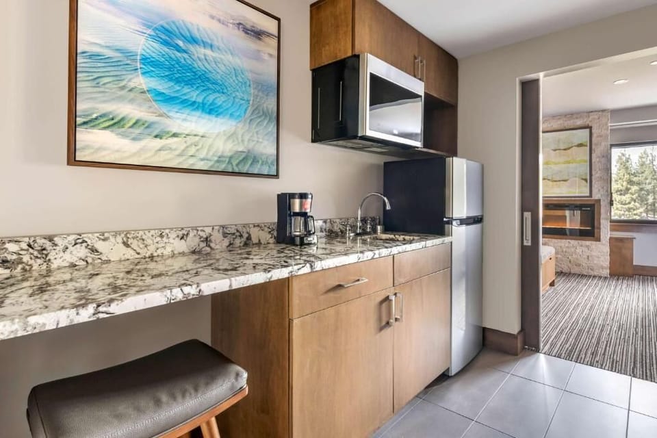 Brew morning coffee and prep snacks on sleek stone counters.