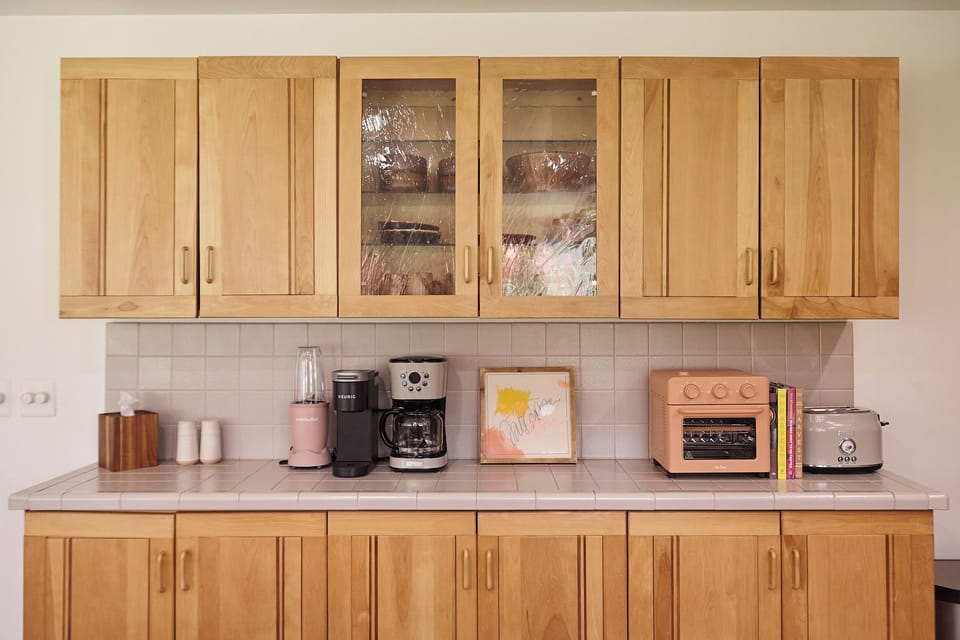 The kitchen is fully-stocked with every modern convenience including a Nutribullet Pro, Our Place air fryer/ toaster oven, Keurig single serve, brewed coffee maker, toaster, microwave, electric tea kettle & more.