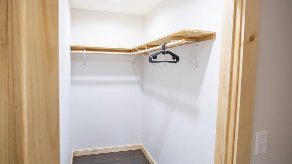 Walkin closet with hangers and laundry hamper