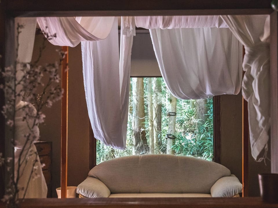 ・[Fall Side] From the bed, you can see the greenery of the trees through the large window.