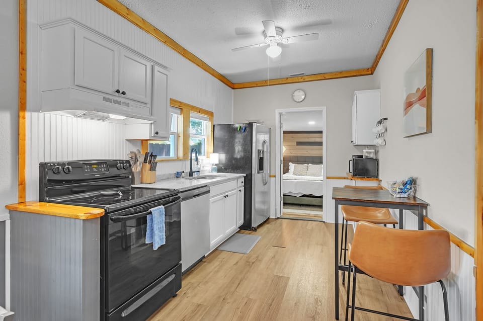 Cook up a feast in this fully equipped, modern kitchen, featuring stainless steel appliances, ample counter space, and a cozy dining nook.