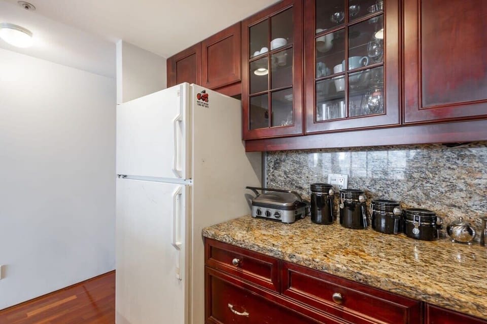 The kitchen is designed to meet all your cooking needs, featuring spacious granite countertops and high-end appliances.