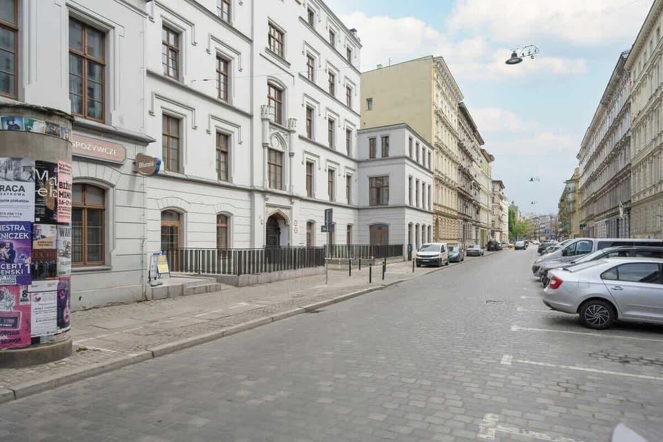 A city street lined with historic buildings and parked cars. A typical urban street in a European city.
