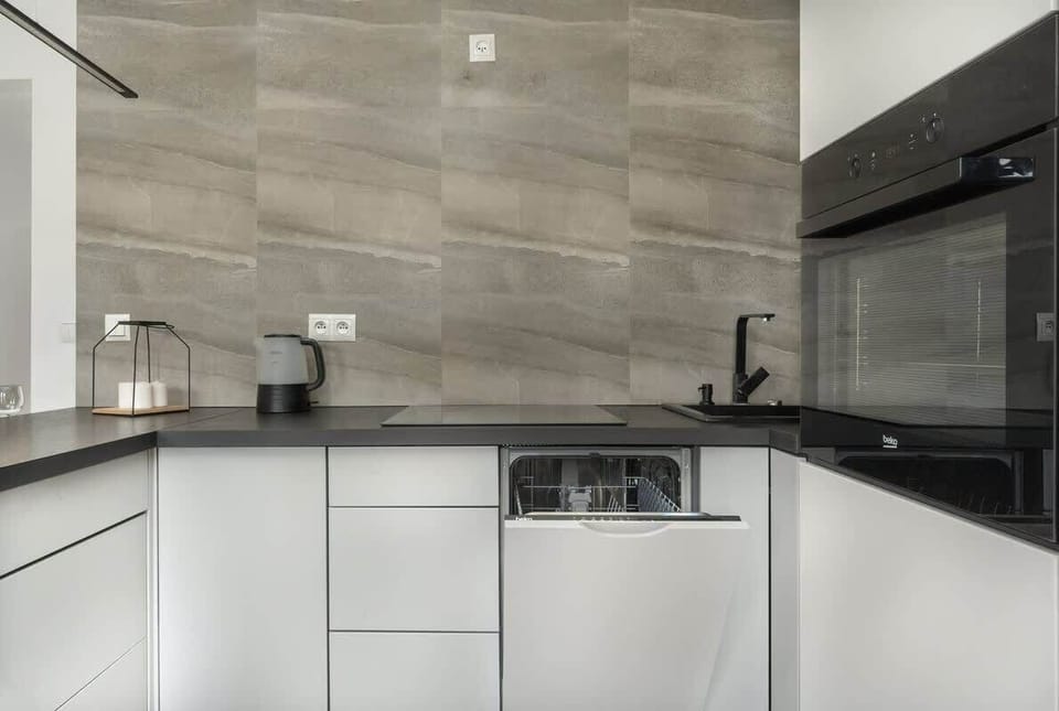 A modern kitchen with glossy cabinets and built-in appliances. Great for preparing both quick and elaborate meals.