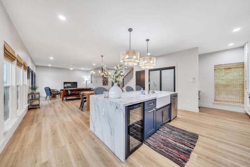 The White House offers a thoughtfully designed chef’s kitchen complete with a sleek waterfall island, wine fridge, built-in trash compartment, farmhouse sink, and glass rinser—perfect for crafting delicious meals and bringing everyone together.