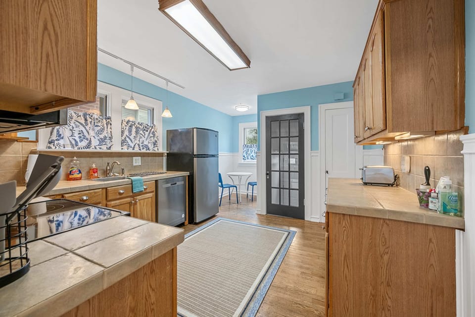 Step into our inviting kitchen, where the combination of serene blue walls and rustic wood cabinets will make you feel right at ease. 😌✨ Embrace the warmth and enjoy the delightful moments that await you here! 🌟🍽️