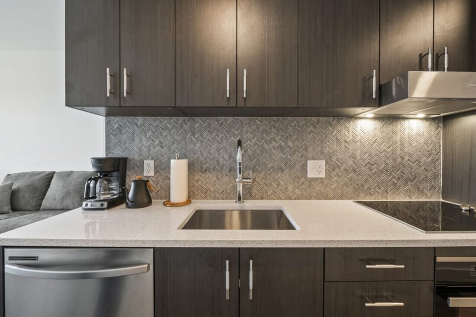 Large kitchen with plenty of cupoards, dishwasher, sink, stove top