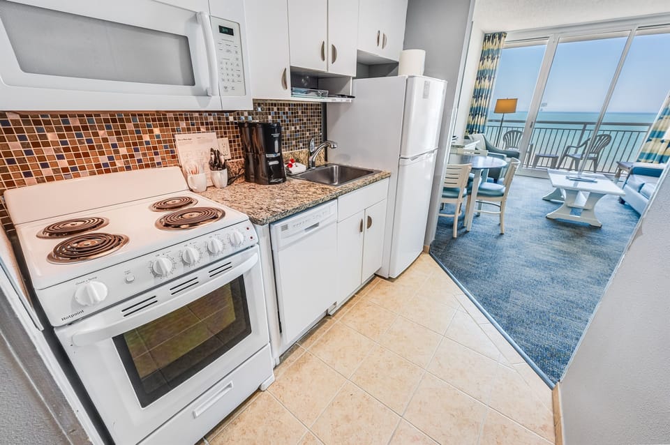 - Kitchen opens to dining and living area with ocean view balcony   - Fully equipped appliances coffee maker and cookware for guest use   - Bright space ideal for enjoying breakfast before beach adventures