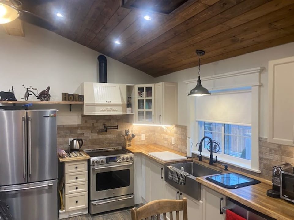 Fully equipped kitchen with dishes, pots, cutlery, spices, and more for cooking.