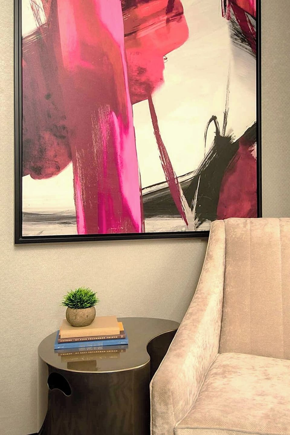 Relax with a book beside modern art and cozy seating.