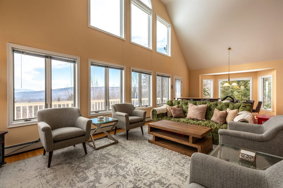 Spacious and sunlit main living room featuring panoramic mountain views — the perfect spot to relax and unwind after a day of adventure.