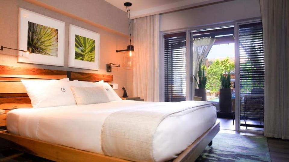 Unwind in crisp linens with a breezy balcony view.