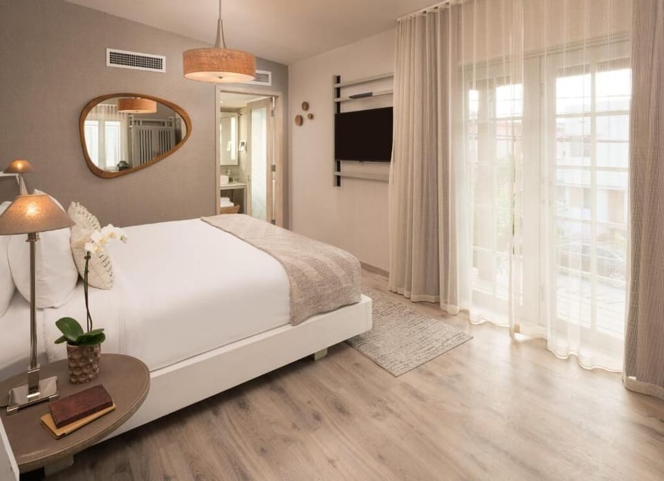 Wake up to sunlit mornings beside breezy floor-to-ceiling curtains