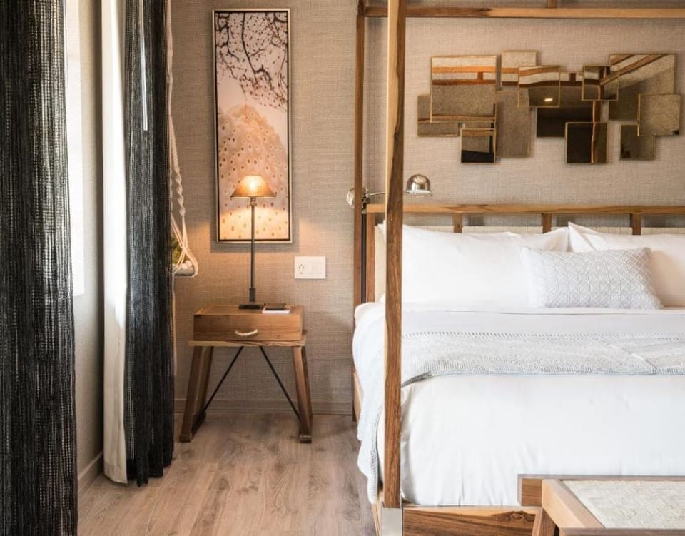 Sink into crisp linens framed by warm wood and artful décor