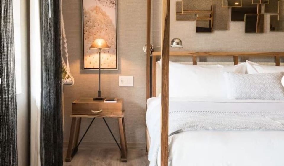 Linger in warm lamplight beside the elegant canopy bed.