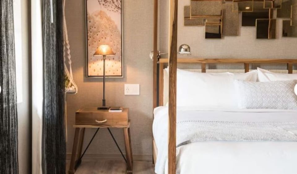 Linger in warm lamplight beside the elegant canopy bed.