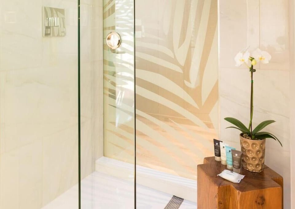 Step into a sleek glass shower for a relaxing rinse.