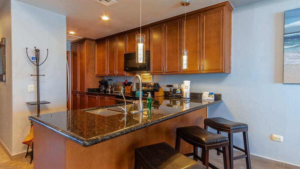 kitchen with many cabinets, full appliances, bar stools