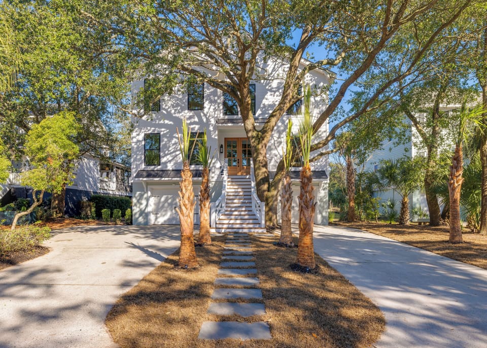 Stunning coastal home framed by palm trees, offering a warm Lowcountry welcome just steps from the beach