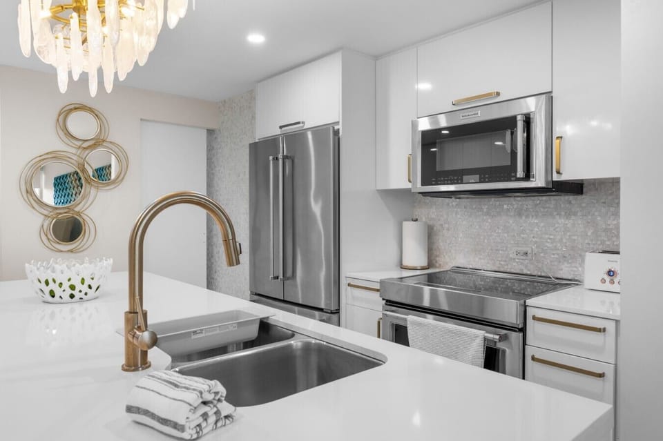 Kitchen detail with gooseneck faucet, gas range, and French-door refrigerator