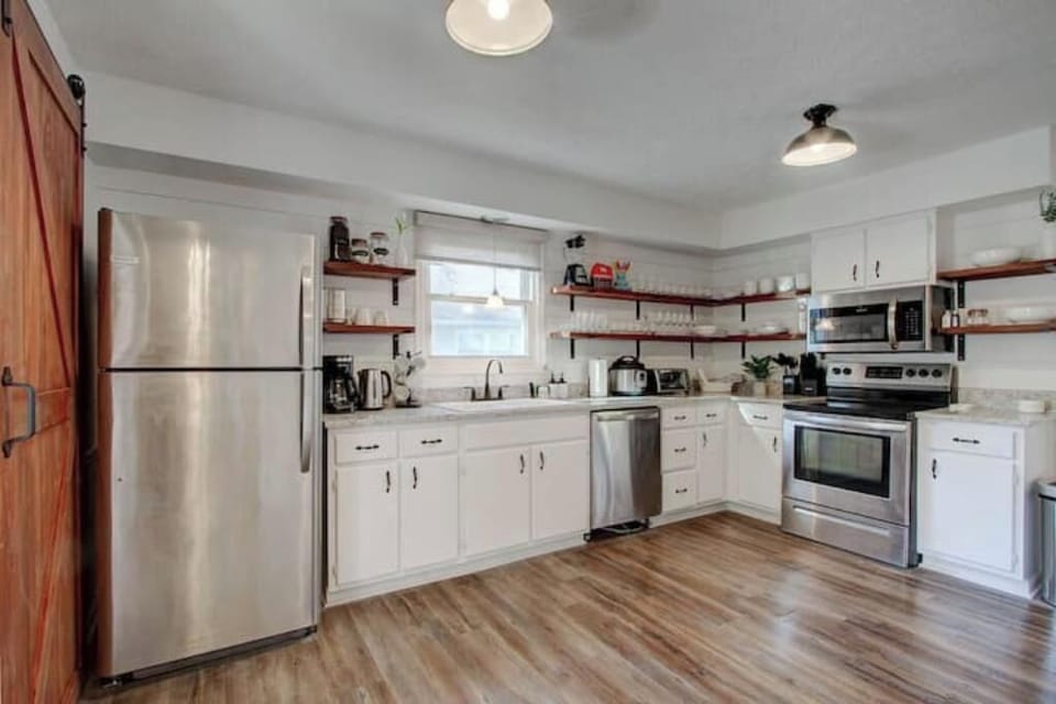 Fully stocked kitchen with stainless steel appliances.