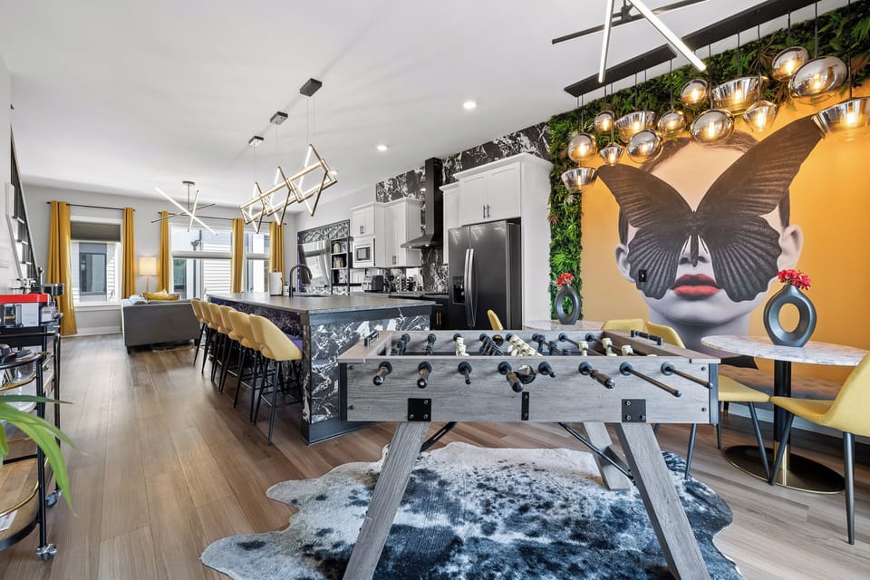 The Gathering Hub: Two dining tables and foosball open to the chef's kitchen